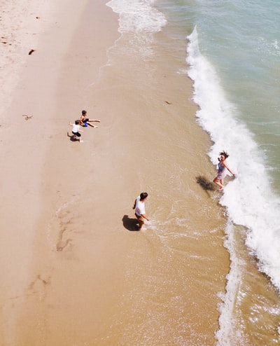 一家四口白天在海边玩耍